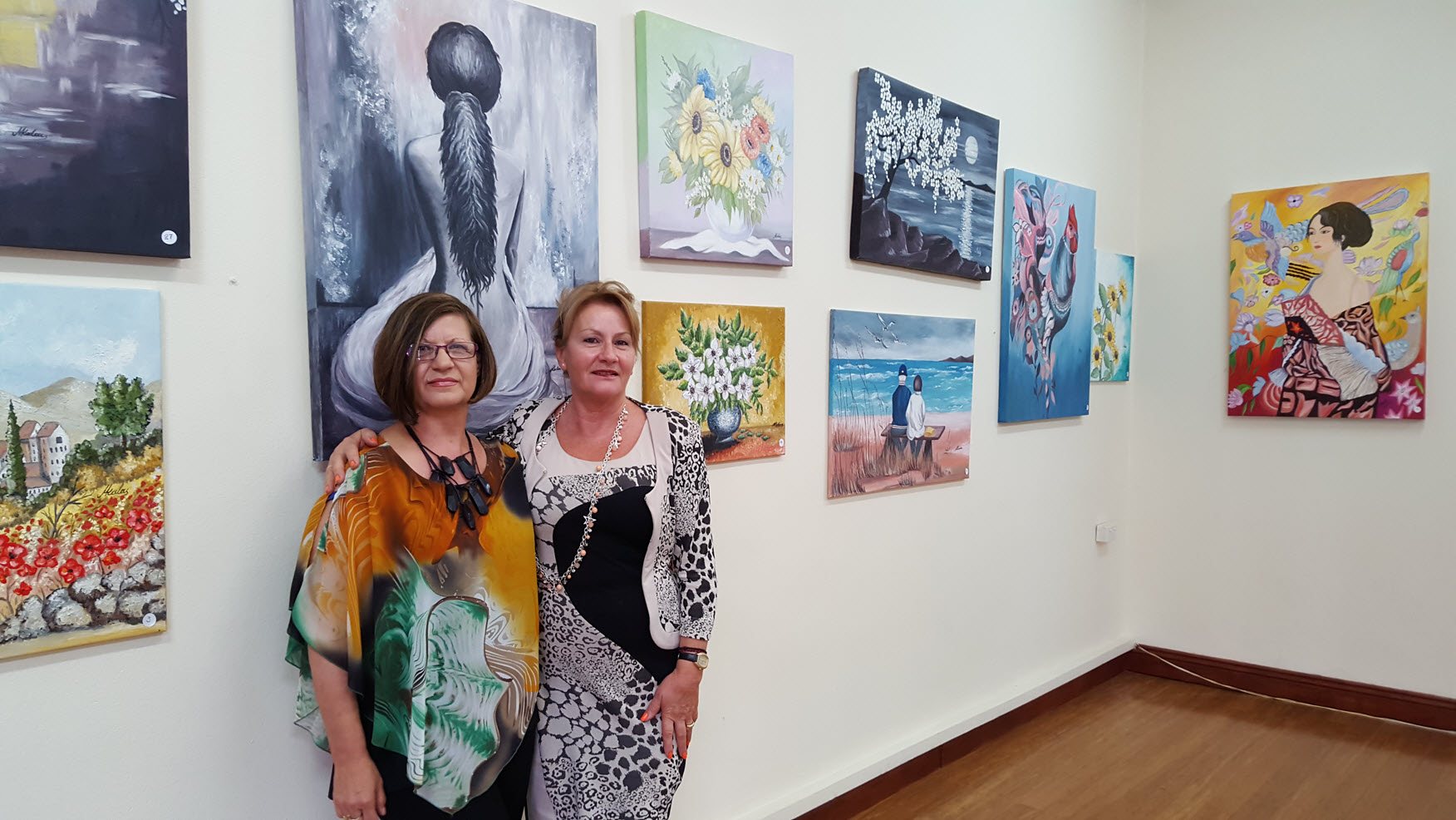 Artist Mary Kalaitzis with Toula Mavroudis among the paintings